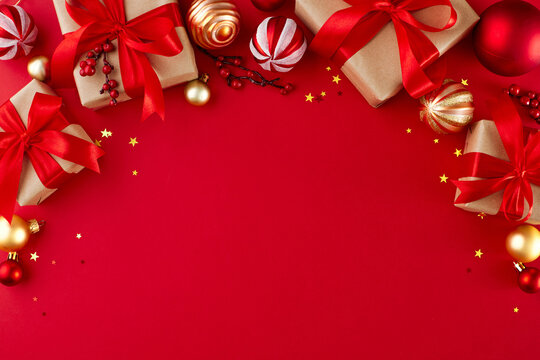 Prepare for the upcoming year by choosing heartfelt gifts. Top view photo of gift boxes, сhristmas decorations, golden stars on red background with promo space