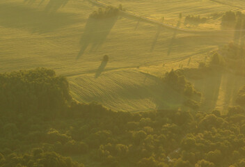 Field at dawn, aerial view. Foggy sunrise. Nature at dawn in fog, aerial view. Rural landscape. Morning mist haze. Misty landscape. Sunny foggy hills on sundown.