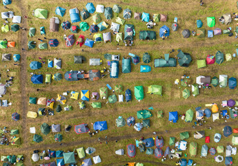 Tents camp, top view. Rest with a tent in nature. Mass camping with colorful tents, aerial view....