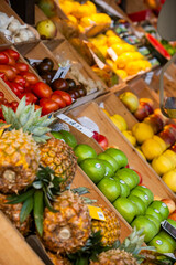 Pineapples, apples, tomatoes and lemons in a greengrocer's market