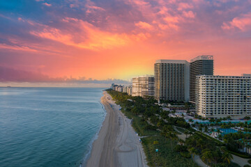 aerial shot of hotels, luxury condos and skyscrapers along the coastline at sunrise at Bal Harbour...