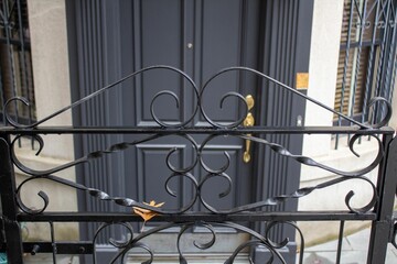 the black iron gate of a building and some yellow scissors
