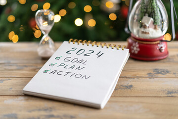 Notepad with plans for the next year and the inscription - 2024 goal, plan, action - obrazy, fototapety, plakaty