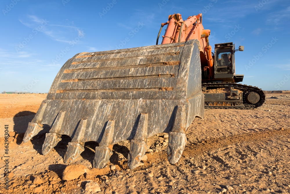 Wall mural excavator on earthmoving at open pit mining. backhoe dig sand or gravel in quarry. heavy constructio