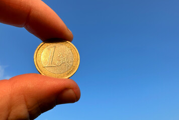 Euro coin cash in hand on blue sky background. Euro Money for pay. Euro bills and coins in Crisis...