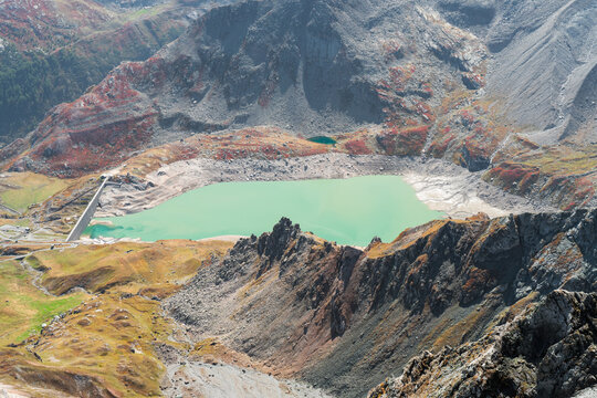 Serr&ugrave; Lake and dam (Ceresole Reale, Orco Valley) Gran Paradiso National Park. colorful mountain landscape in autumn