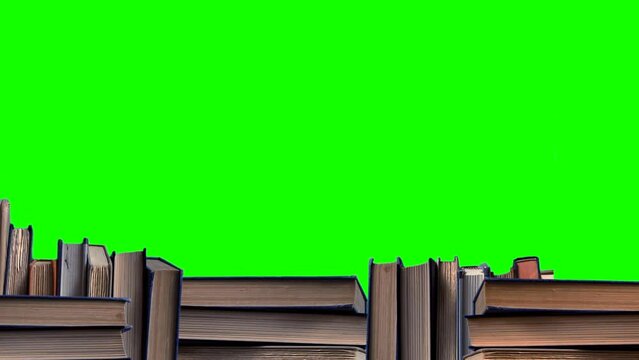 Stacks of old books rising on a green screen