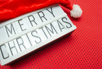 luminous sign with Santa hat written "Merry Christmas" on a red background