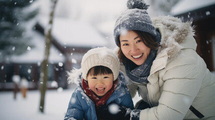 Fototapeta na wymiar Happy mother and daughter having fun together outdoors playing with snow.