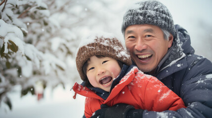 Fototapeta na wymiar Portrait of happy asian father and child in snow.