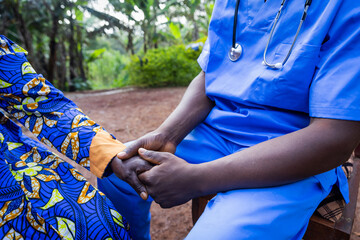 Health professional holding an elder patient's hand to comfort her