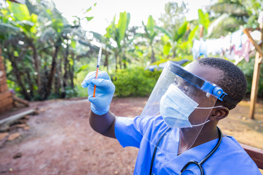 African young doctor with syringe preparing to vaccinate people