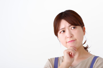 Naklejka premium 腕組みをして考え事をするエプロン姿の女性