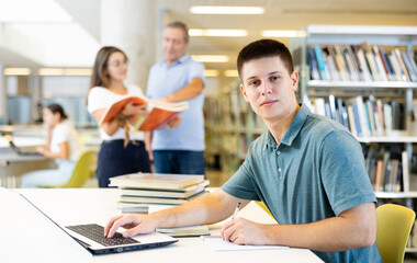 School student doing research on project in the college library