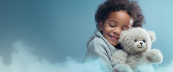a child holding a stuffed animal on a blue background with copy space