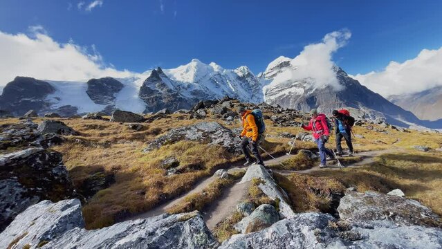 Three expedition members with backpacks together following Makalu Barun Park trekking route near Khare. Mera peak climbing acclimatization walk. Backpackers using trekking poles, enjoying valley view.