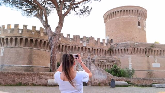 Girl photographing the castle of Ostia Antica