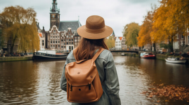 Tourist Woman with Hat and Backpack in Amsterdam, Netherlands. Wanderlust concept.