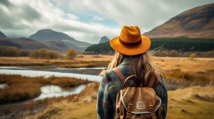 Fototapeta na wymiar Tourist Woman with Hat and Backpack in Scotland. Wanderlust concept.