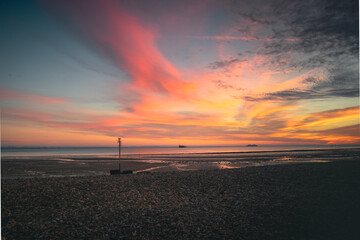 A stunning sunset in the sky on a beach