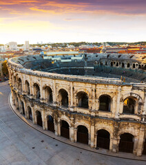 Aerial view of Roman amphitheatre on background with cityscape of Nimes, France