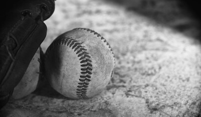 Old used baseball ball for sport in black and white with copy space on grunge texture background.