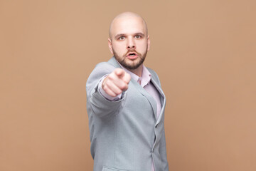 Man having mad expression pointing his finger at camera, looking angrily and frowning as if...