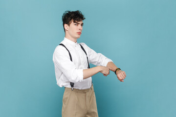 Portrait of impatient angry man wearing white shirt and suspender pointing at wrist watch and...