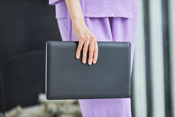 A girl is holding a laptop in her hands - an excellent device for a businesswoman. Technology not only helps speed up learning but also allows you to be mobile.
