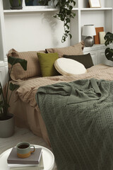 Fototapeta na wymiar Comfortable bed and different houseplants in bedroom. Interior design