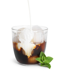 Pouring milk into glass of iced coffee on white background