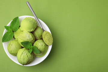 Tasty matcha ice cream and spoon with powder in bowl on green table, top view. Space for text