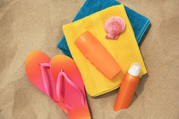 Fototapeta na wymiar Flat lay composition with sunscreens on sand. Sun protection care