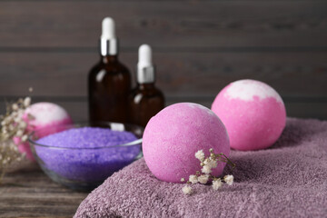 Beautiful aromatic bath bombs, gypsophila flowers and soft towel on table, closeup. Space for text