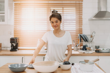 Portrait of happy asian woman preparing breakfast in the kitchen in the morning.