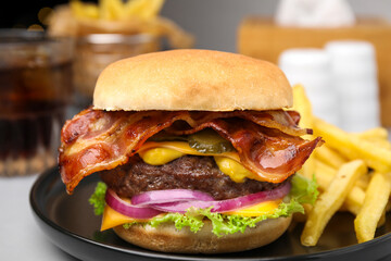 Tasty burger with bacon, vegetables and patty served with french fries on light grey table, closeup