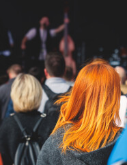 Fototapeta premium Crowded open air festival concert with scene lights with musicians band on stage at the venue, rock show performance, with concert-goers attendees, audience on dance floor during summer festival