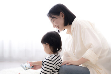子どもと一緒にスマホを見る母親　クローズアップ