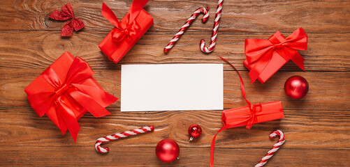 Blank card, Christmas gift boxes and decorations on wooden background, top view