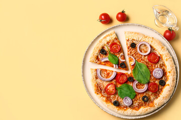 Plate of tasty pizza with basil and tomatoes on yellow background