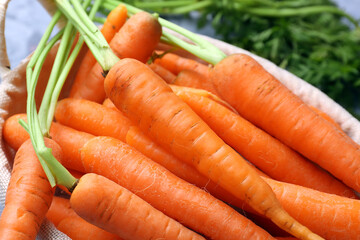 Wicker basket with fresh carrots, closeup