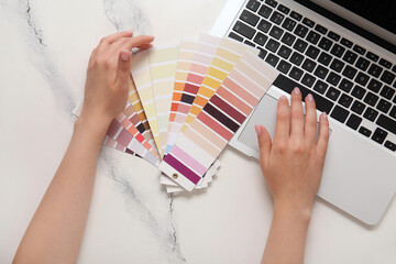 Female hands, many color palettes and laptop on light background, top view