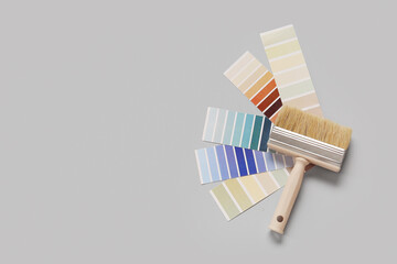 Many color palettes and brush on grey background, top view