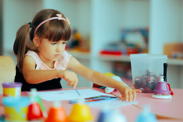 Little Talented Kindergarten Girl Painting in Class . Child expressing her artistic personality in...