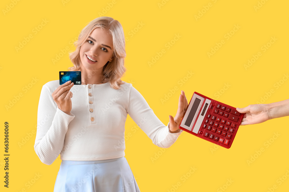 Poster young woman with credit card rejecting calculator on yellow background