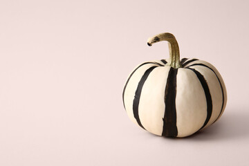 Painted pumpkin with stripes on beige background