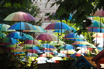 Rainbow umbrella on sky background. Many colorful umbrellas. 