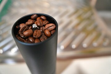 The Fried coffee beans are falling to the manual grinder