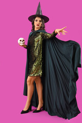 Young witch with skull on purple background