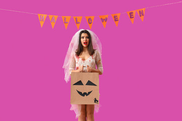 Scared young woman dressed for Halloween as dead bride with gift bag on purple background